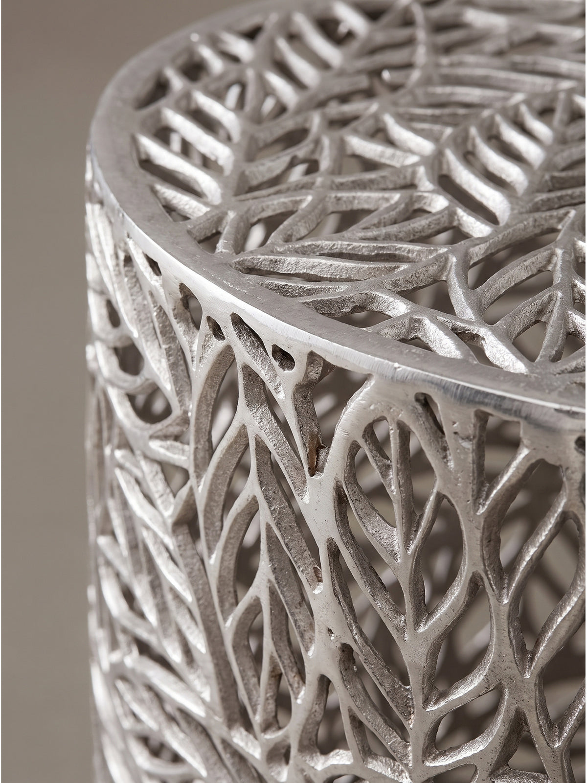 Nahaufnahme der Aluminiumstruktur der Beistelltische mit filigranem Blattmuster und kühlem silbernem Glanz_