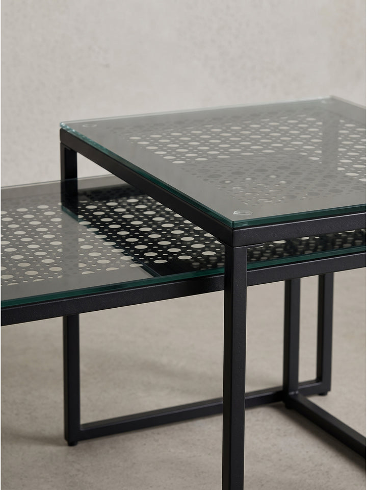 Gesamteindruck der architektonischen Sofatische aus schwarzem Stahl und gemustertem Glas für platzsparende Einrichtungskonzepte._