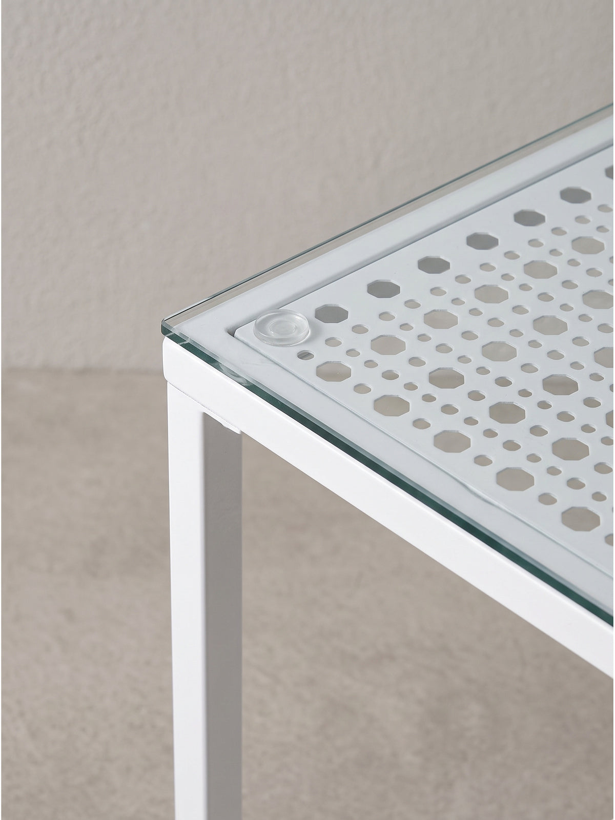 Versetzte Anordnung der beiden Glas-Couchtische mit weißem Metallrahmen fotografiert aus einer leicht erhöhten Perspektive_