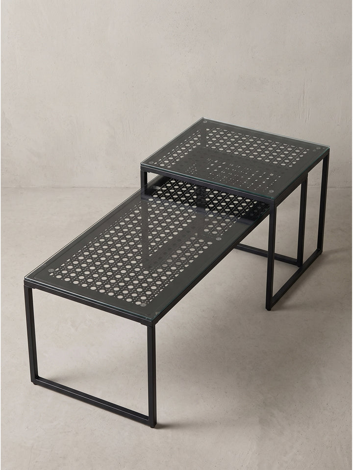 Minimalistischer Beistelltisch mit zwei unterschiedlich hohen Elementen aus halbdurchsichtigem Glas und kantigem Stahlgestell._