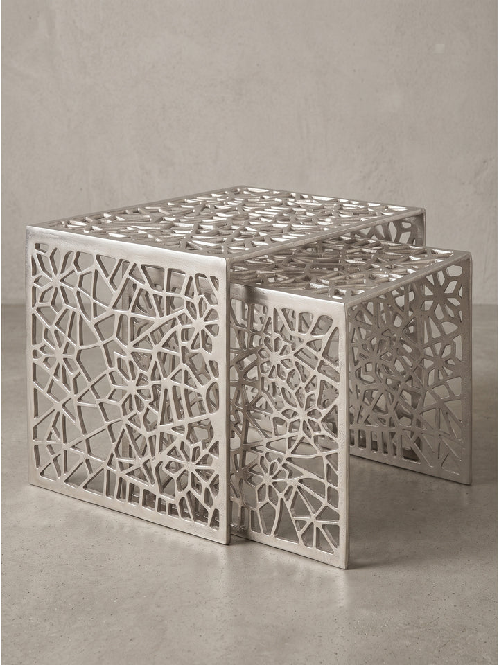 Rechteckiger Loungetisch aus glänzendem Aluminium im 2er-Set mit unregelmäßigem Spinnennetz-Muster vor neutralem weißen Hintergrund_