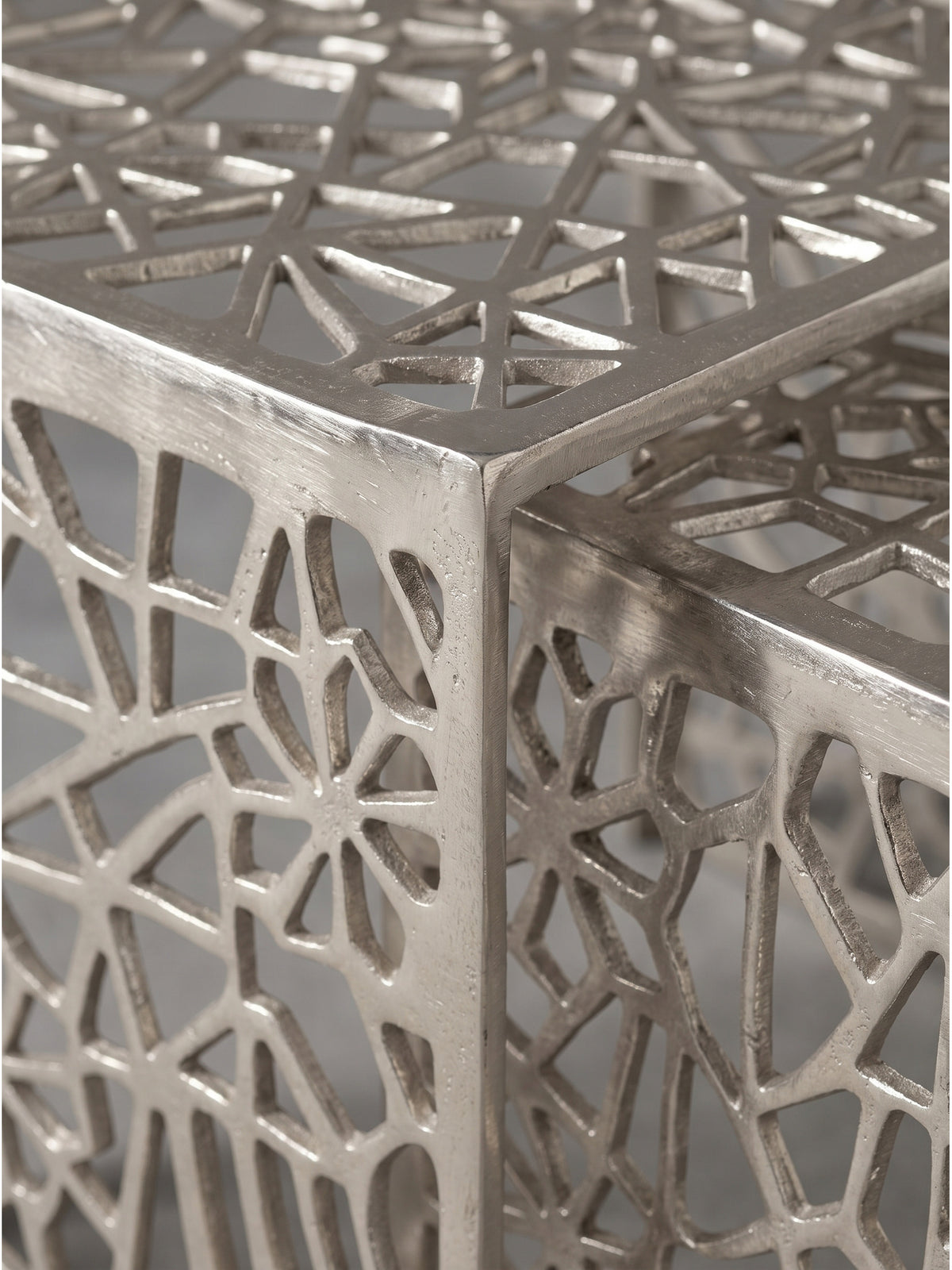 Detaillierte Nahaufnahme des abstrakten Gittermusters aus gegossenem Aluminium in glänzender Silberoptik mit sichtbarer feiner Metallstruktur