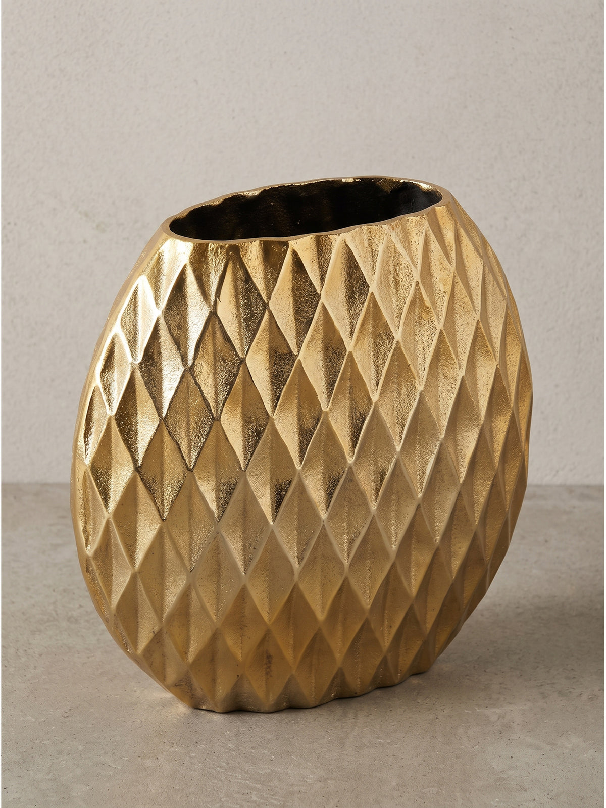 Frontalansicht der runden, bauchigen Tischvase aus massivem Aluminium in strahlendem Gold freigestellt vor einem neutralen weißen Hintergrund._