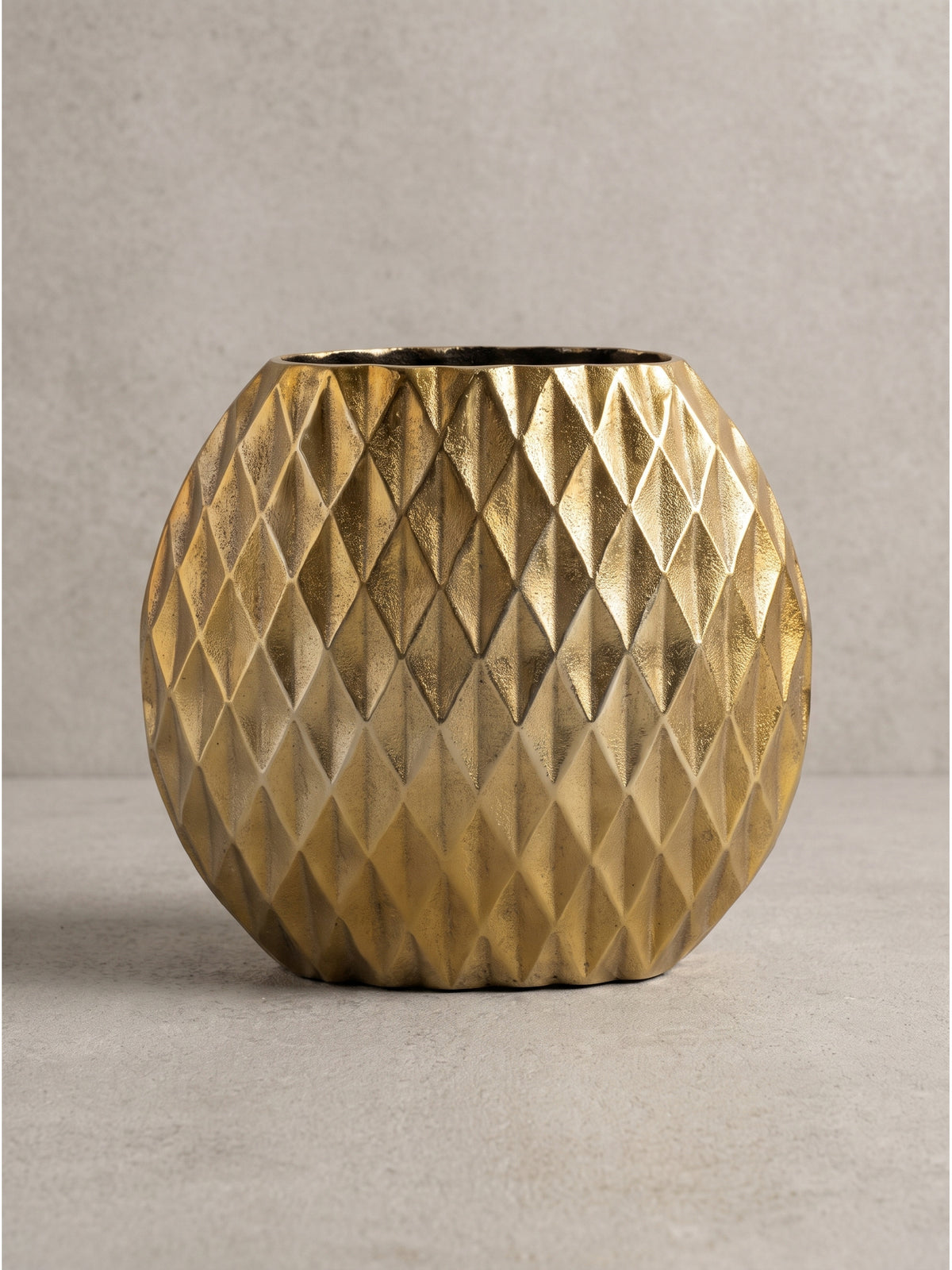 Seitenprofil der flachen Tischvase aus strukturiertem Aluminium in Gold, ideal positioniert für stilvolle Arrangements auf Fensterbänken oder Kaminen.