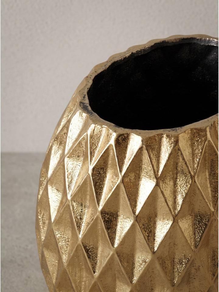 Detailreiche Darstellung der weiten ovalen Öffnung der goldenen Aluminium-Tischvase, die perfekten Halt für opulente und ausladende Trockenblumen bietet._