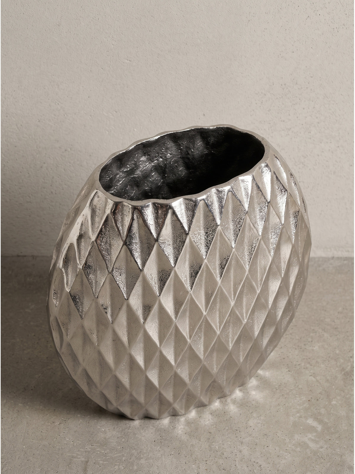 Elegante Dekovase aus Metall in der leichten Seitenansicht, welche die schmale Tiefe des silbernen Korpus von 13 cm deutlich zeigt._
