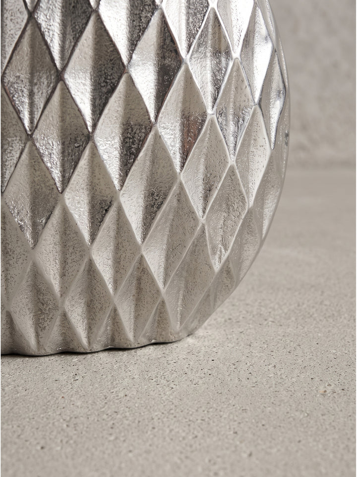 Alternative Perspektive der modernen Alu-Vase in Silber, deren glänzende Oberfläche kühle Lichtreflexe in der Umgebung erzeugt._