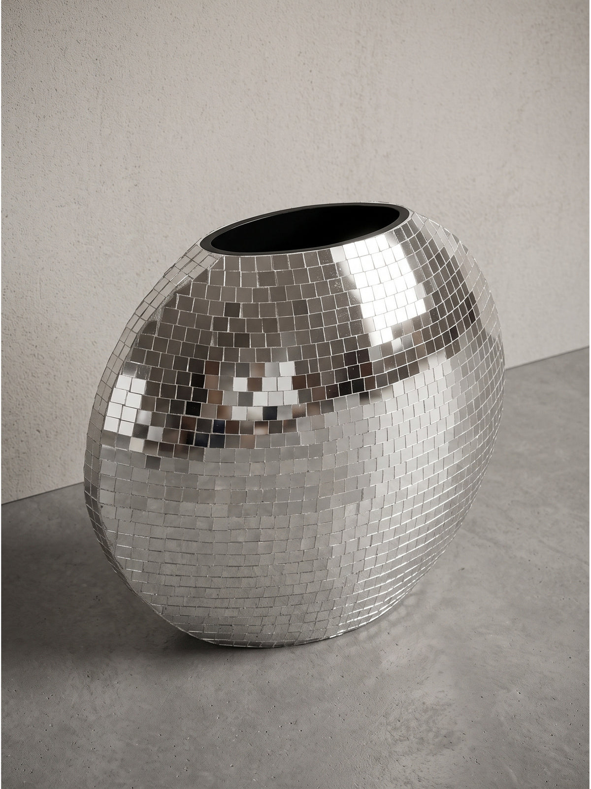 Moderne Tischvase im Mosaik Design aus glänzendem Metall freigestellt vor weißem Hintergrund leicht gedrehte Ansicht