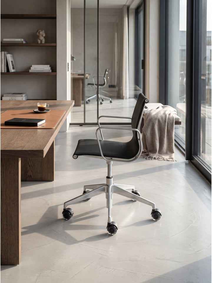 Bürostuhlrollen Set aus kratzfestem Kunststoff und schwarzem Metall kombiniert mit einem ergonomischen Mesh-Bürostuhl im lichtdurchfluteten professionellen Arbeitszimmer._