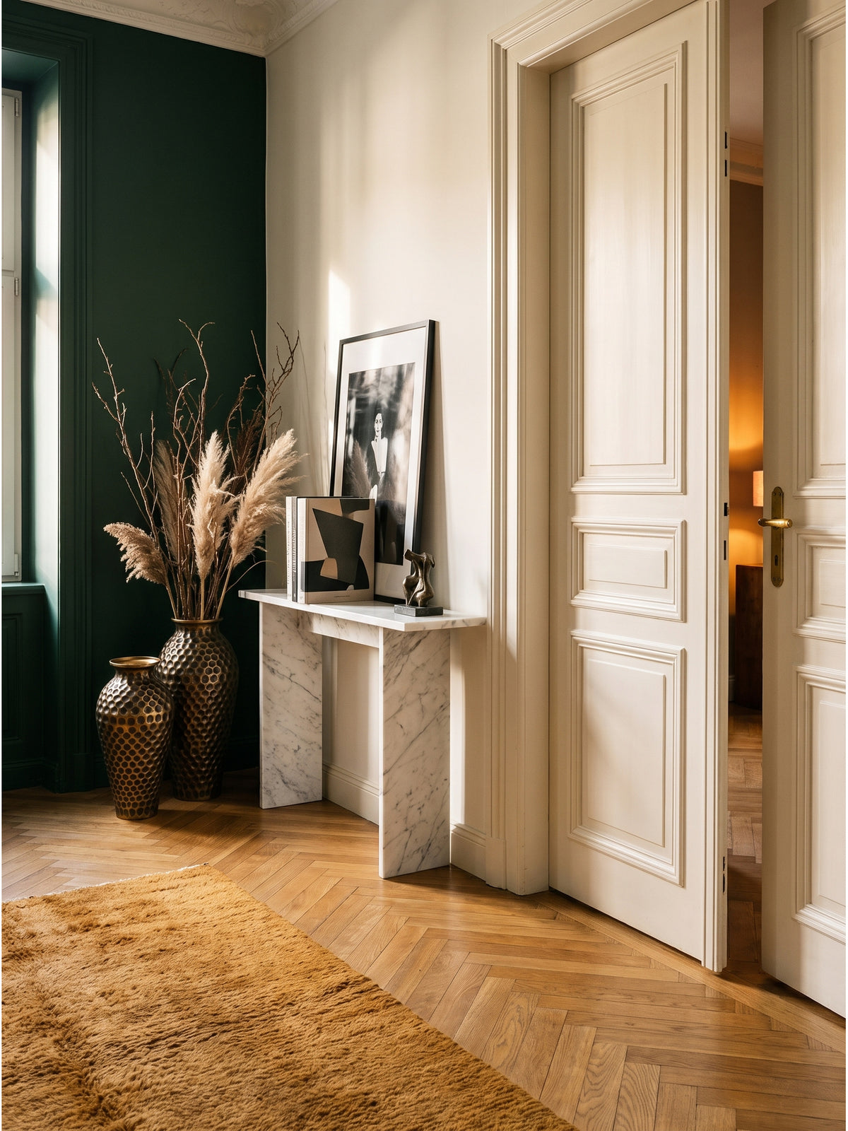 Großes Deko Vase 2er Set aus Aluminium in Gold auf warmem Eichenparkett im eleganten Flur neben einer Konsole_
