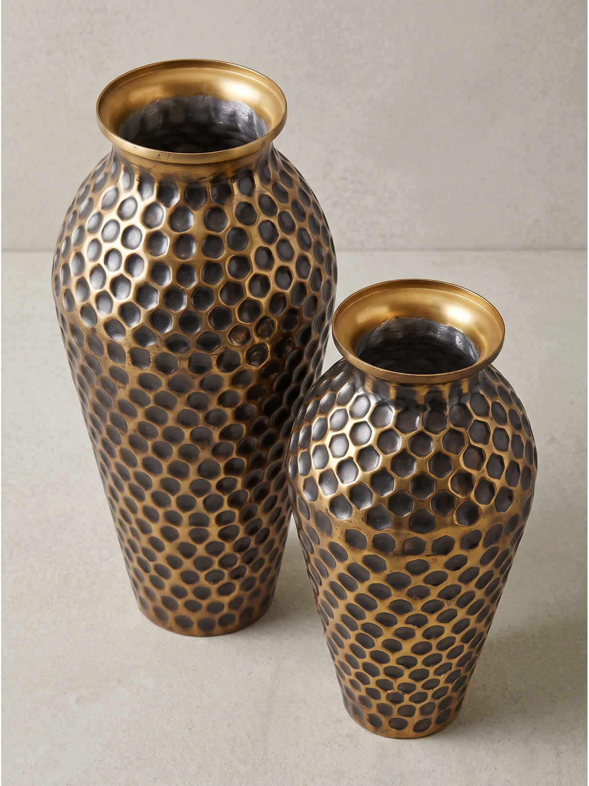 Leicht seitliche Ansicht der goldfarbenen Deko Vase aus Aluminium mit markanter Struktur im stilvollen Set_