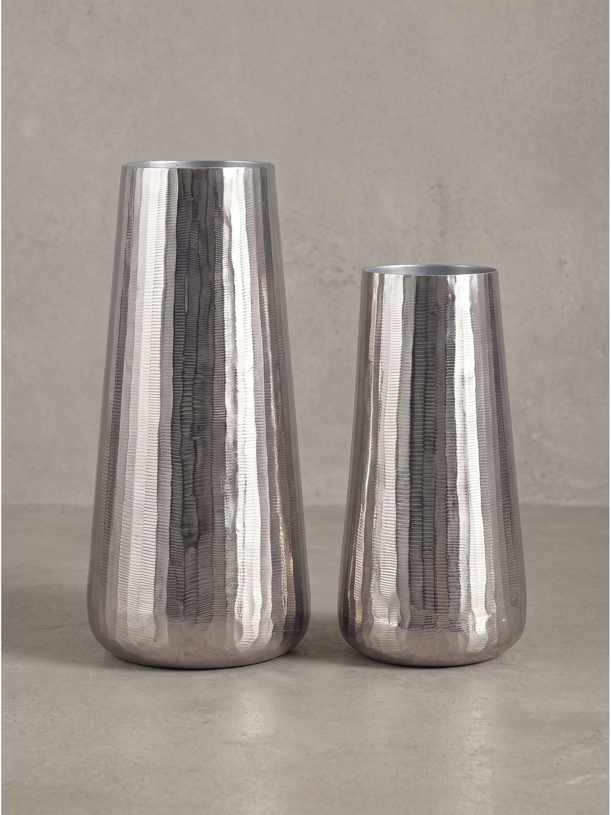 Seitenansicht der schmalen und hohen Silhouetten der 45 cm und 35 cm großen Dekovasen aus silbernem Metall.