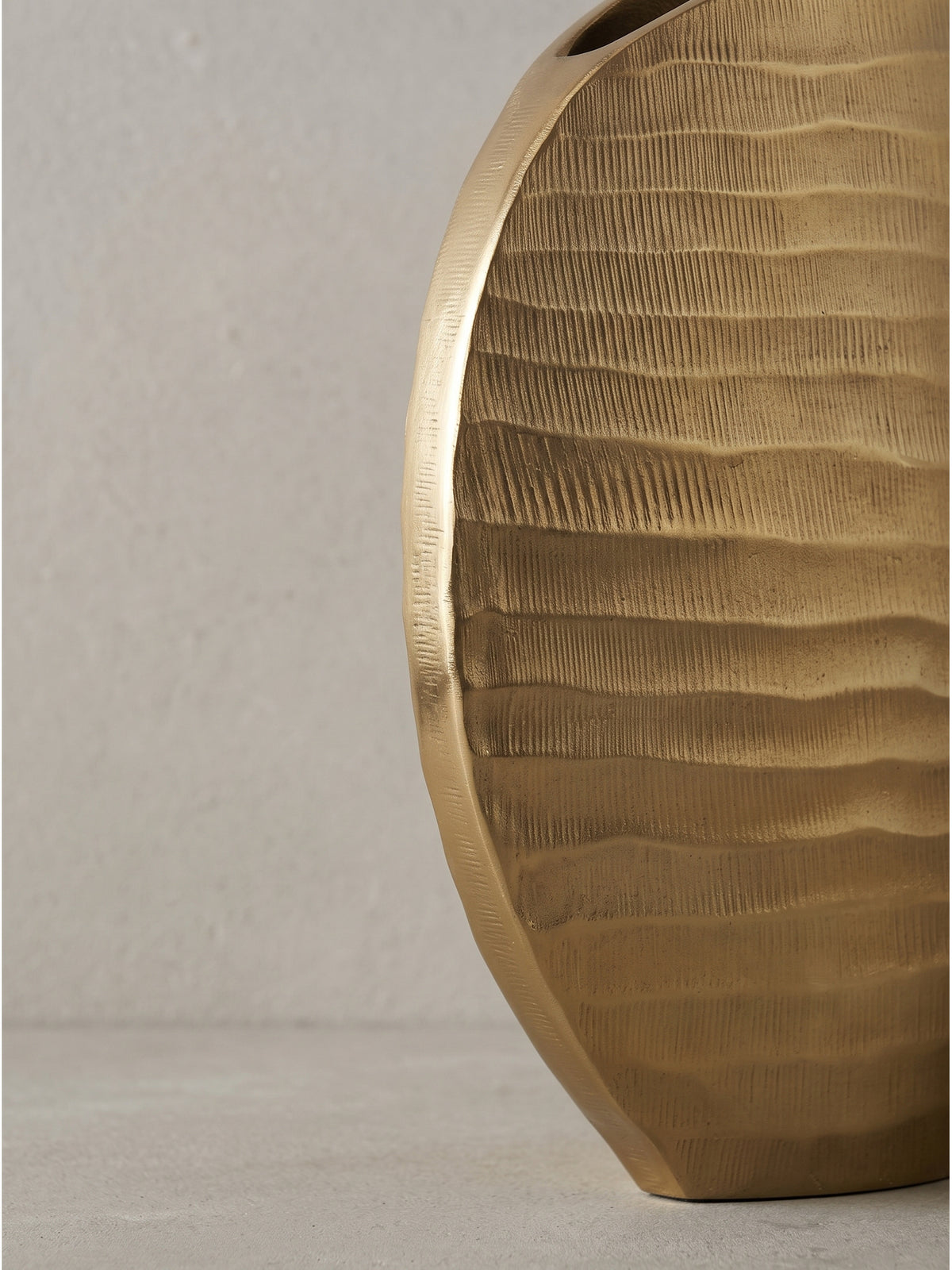 Detailreiche Ansicht der unterschiedlich großen goldenen Wohnzimmer-Vasen aus Aluminium im Zusammenspiel._
