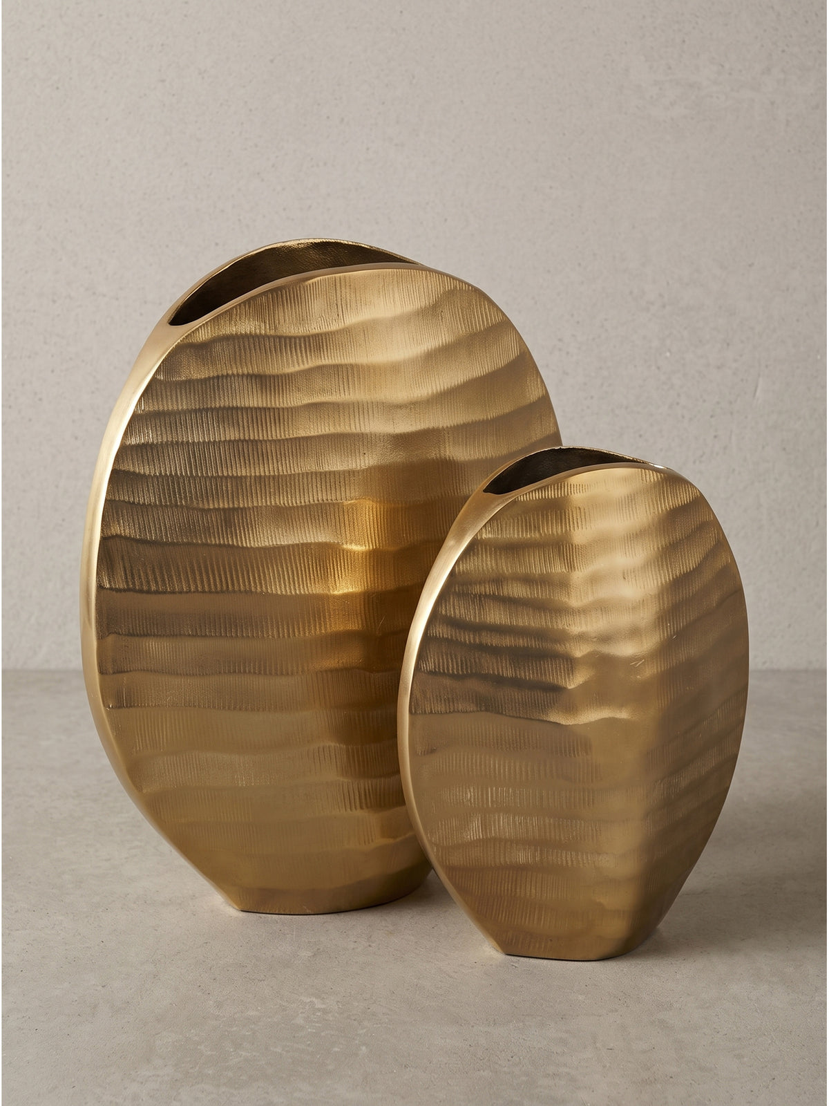 Rundliche Blumenvase aus Aluminium im 2er Set mit goldener Lackierung und moderner Wellentextur in Frontalansicht.
