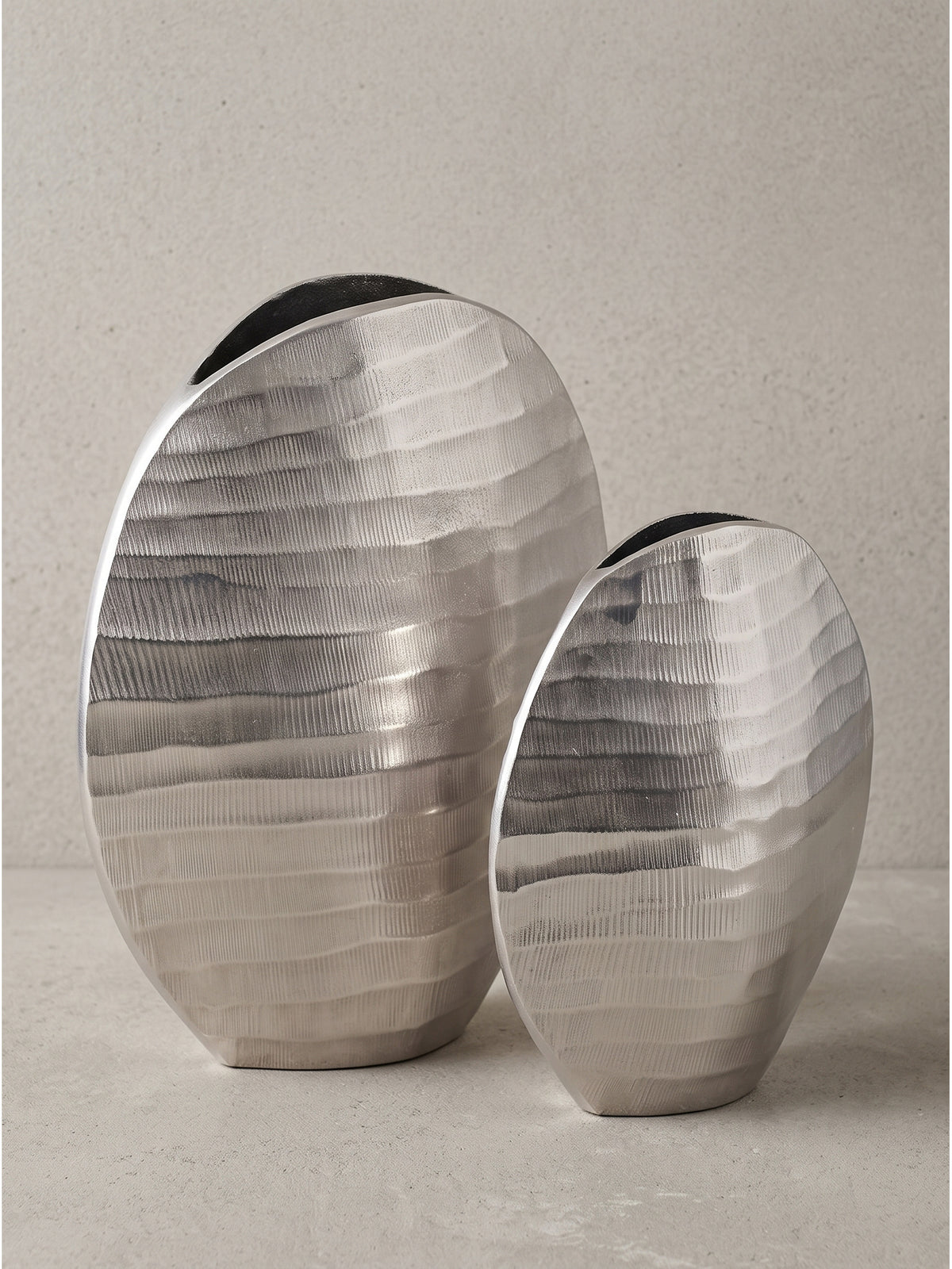 Makroaufnahme der oberen Öffnung der silbernen Blumenvase mit sichtbaren Spuren der massiven Metallverarbeitung._