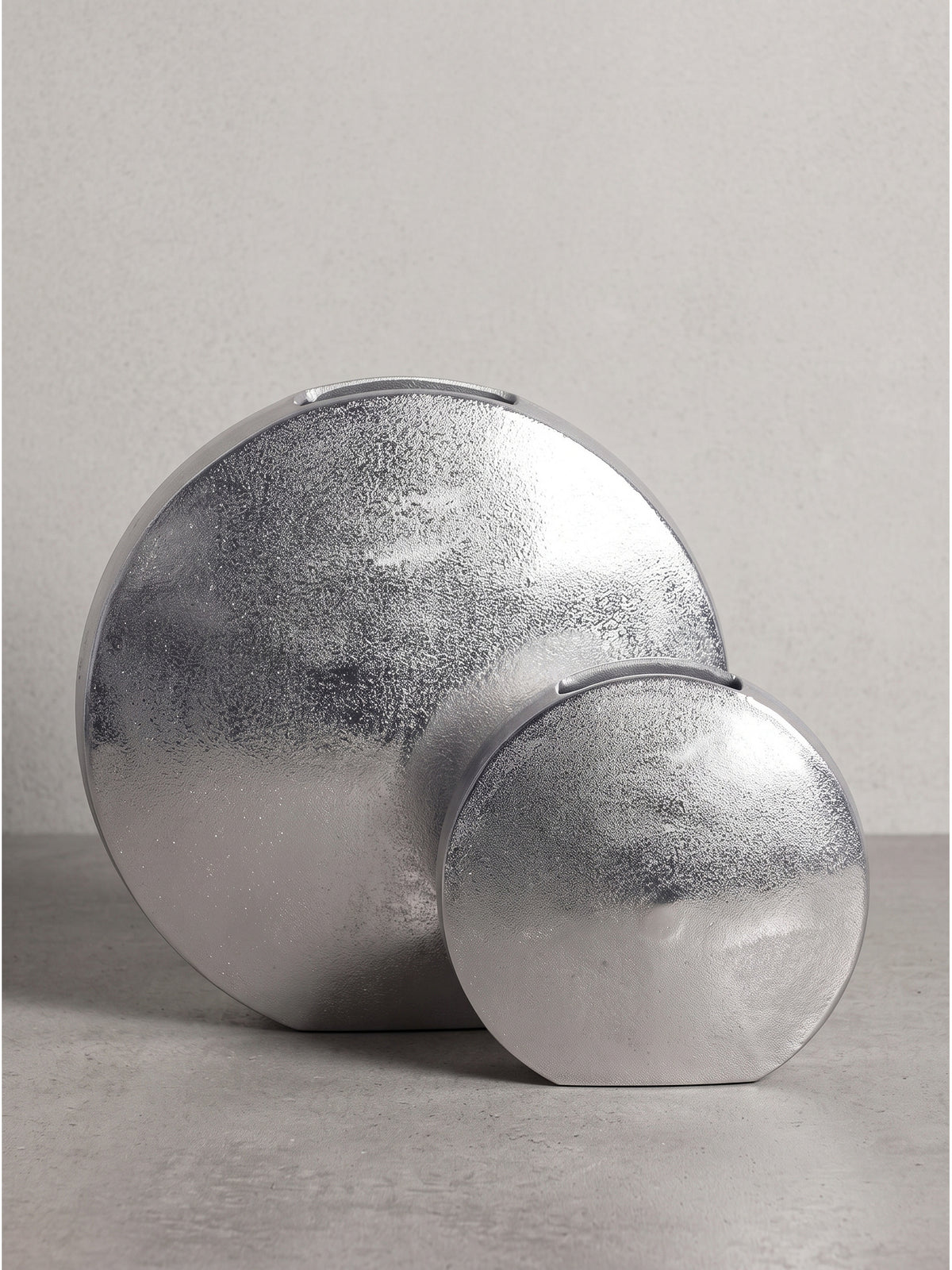 Seitenansicht der flachen runden Blumenvase aus Aluminium mit einer schmalen und stabilen Standfläche._