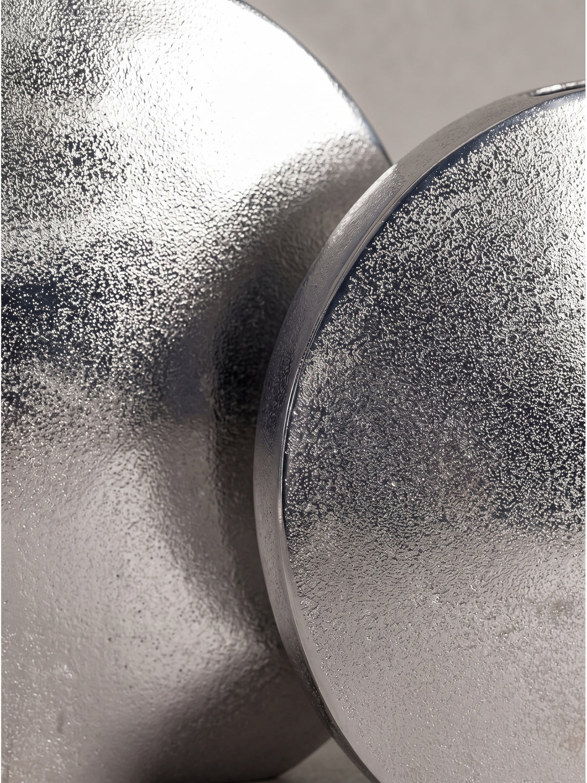 Silbernes Vasen-Set aus Aluminium in runder flacher Formgebung für eine moderne und reduzierte Tischdekoration._
