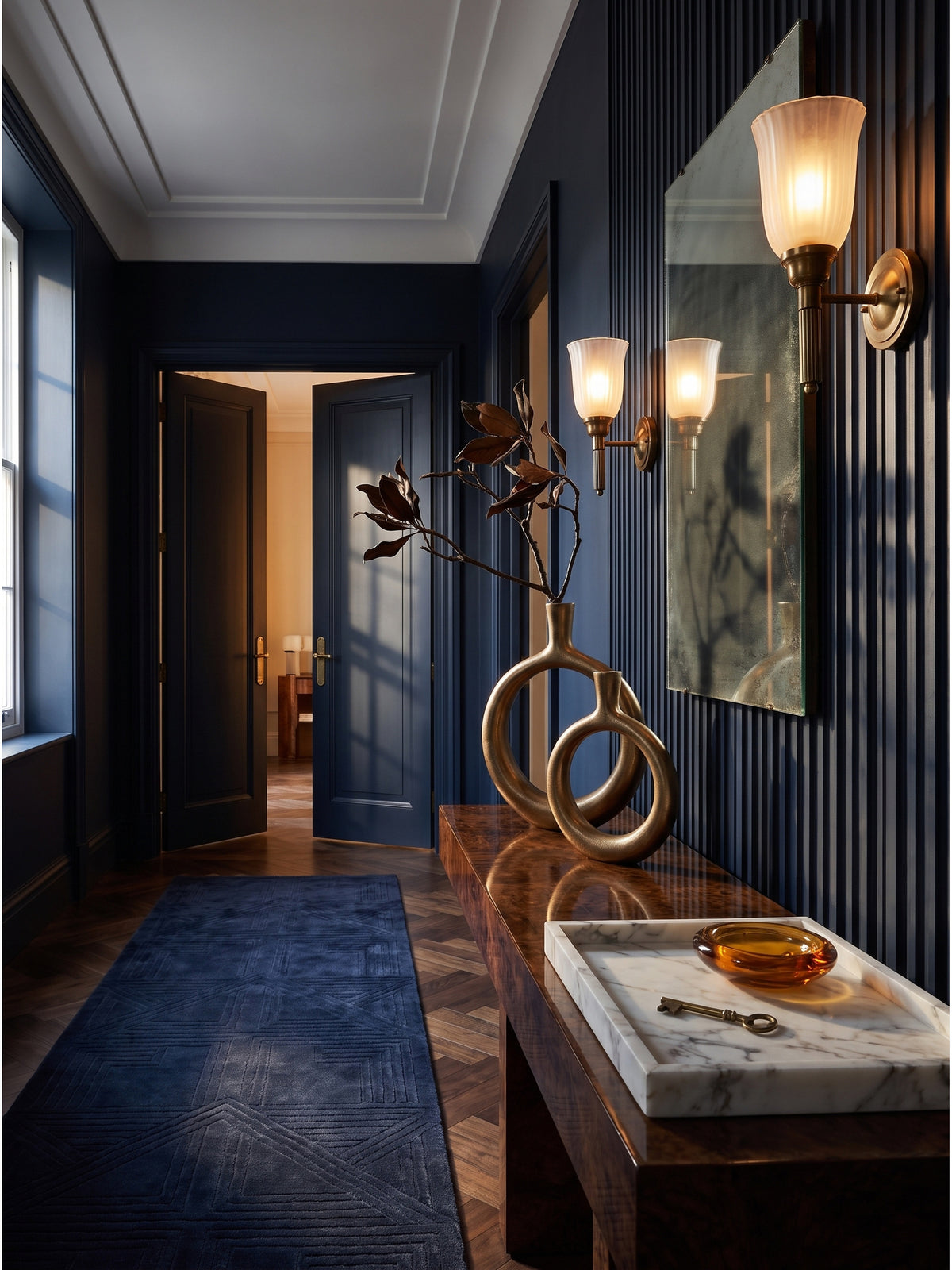 Skulpturales Set aus zwei goldenen Donut Vasen aus strukturiertem Aluminium auf einer dunklen Walnuss-Konsole im luxuriösen Art-Deco Flur