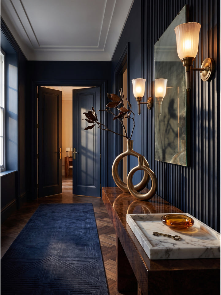 Skulpturales Set aus zwei goldenen Donut Vasen aus strukturiertem Aluminium auf einer dunklen Walnuss-Konsole im luxuriösen Art-Deco Flur_