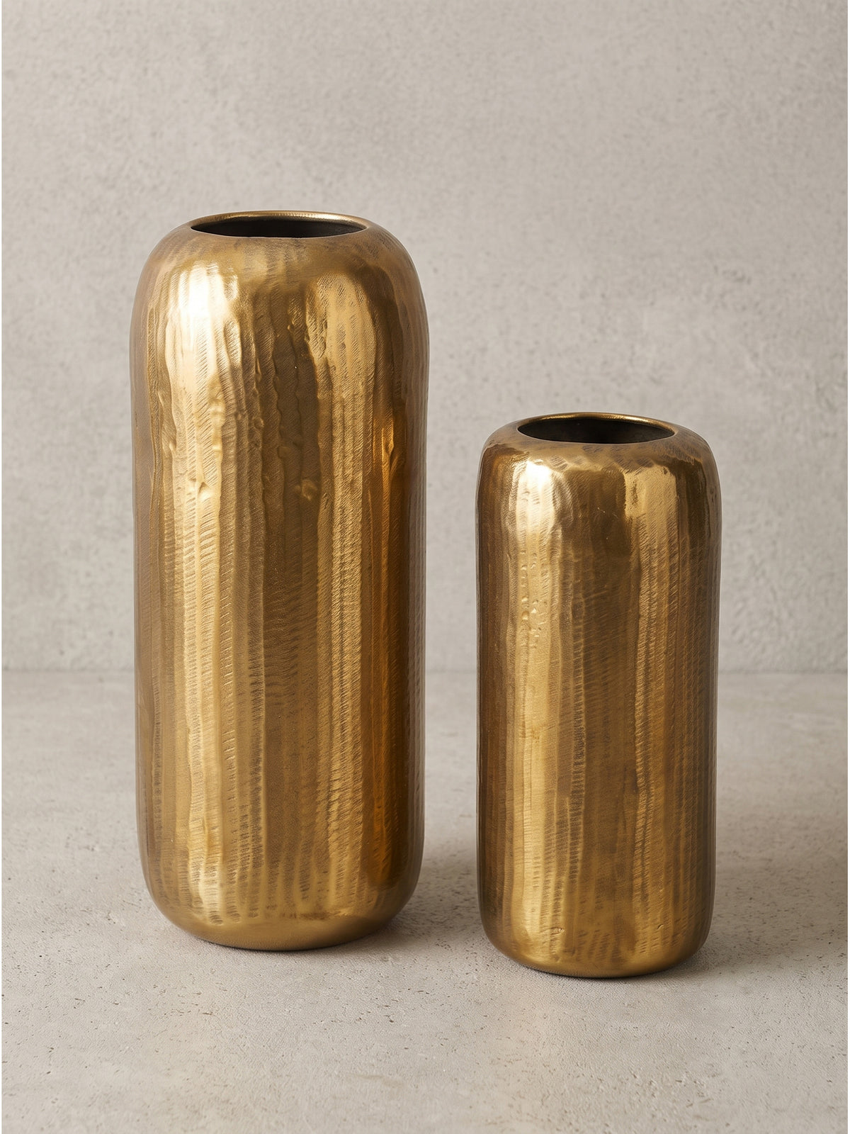Detail der Bodenkante und der gehämmerten Textur der goldenen Metall Blumenvase