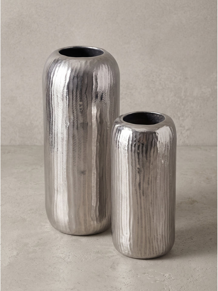 Detailaufnahme der abgerundeten oberen Öffnung und Wandstärke der glänzenden, silber lackierten Zylindervase._