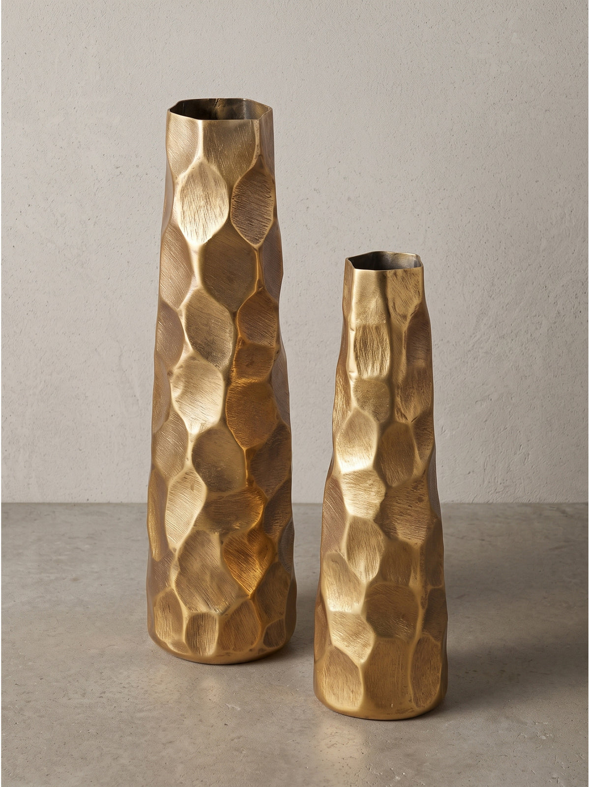 Blick auf den unregelmäßigen Randbereich einer handgefertigten Tischvase aus gold lackiertem Metall