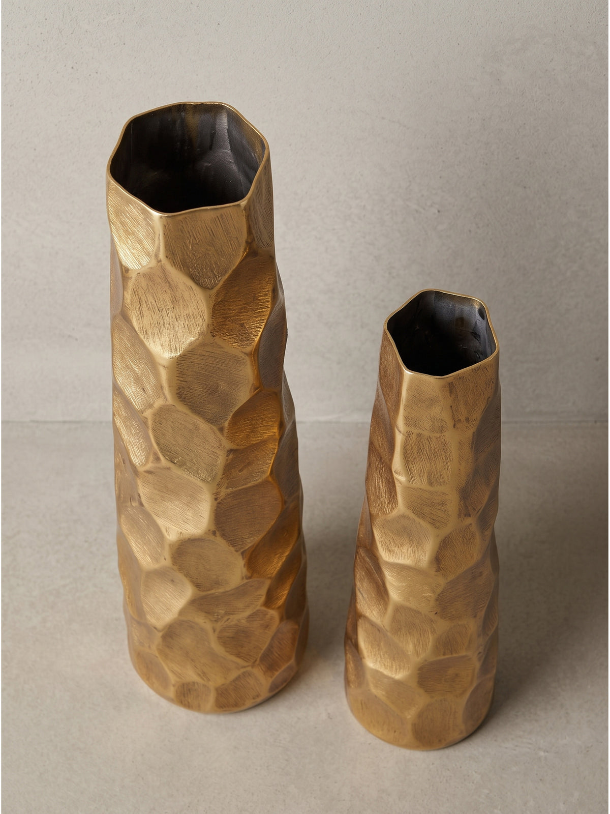 Schlanke goldene Blumenvase aus Aluminium 49cm hoch in leicht gedrehter Perspektive zeigt die organische Randform