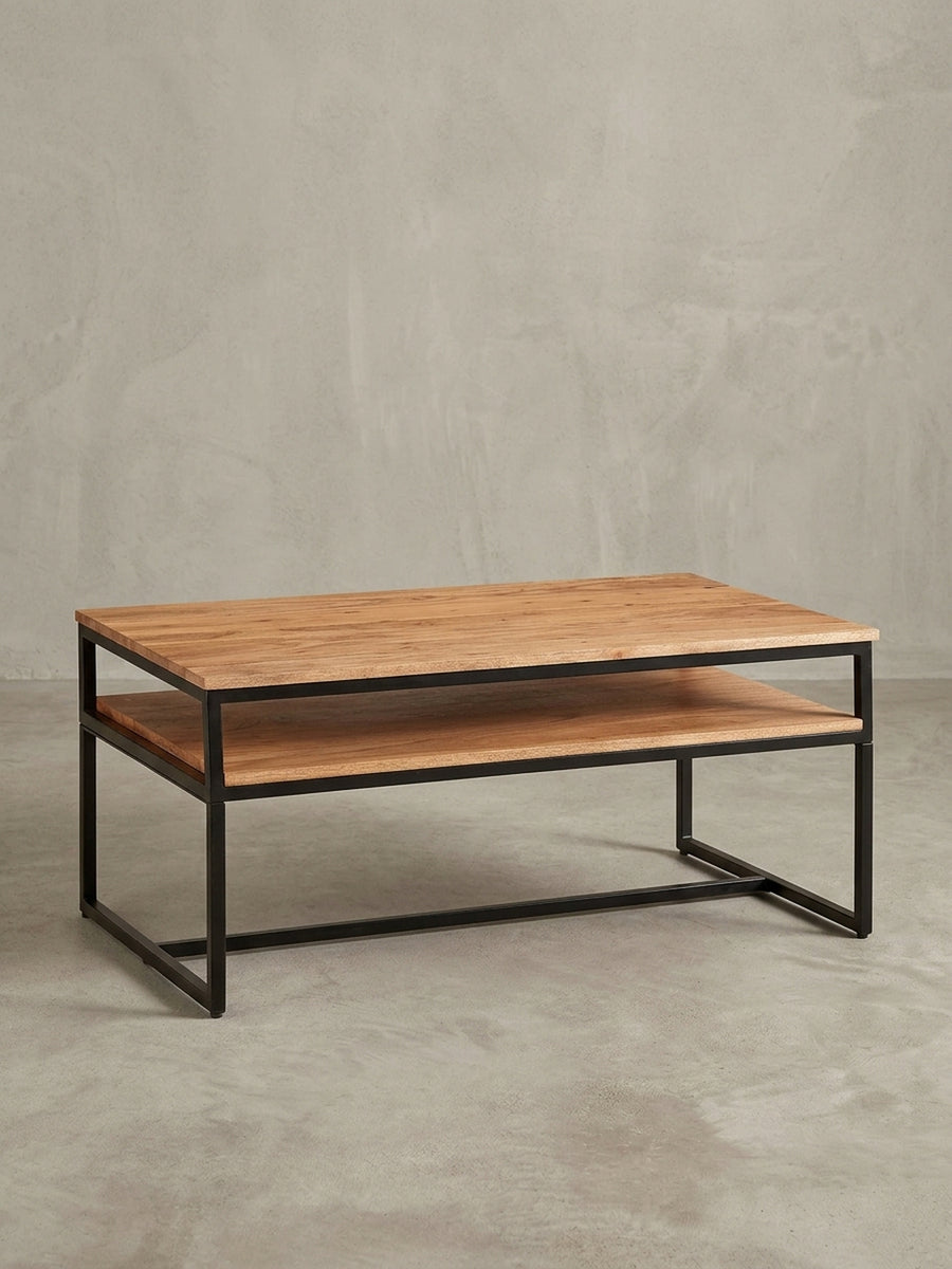 Seitenprofil des Wohnzimmertischs, das die schlanke Silhouette und die Proportionen der beiden Ablageflächen aus Akazienholz verdeutlicht._