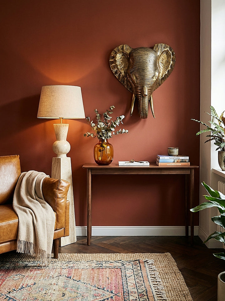 Harmonische Kombination der 41 cm hohen goldenen Wandskulptur mit einem schweren Samtsessel und einer massiven Onyx-Lampe._