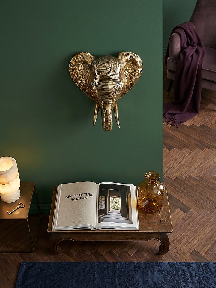 Räumliche Anordnung der goldenen Aluminium-Wandskulptur über einer dunklen Walnuss-Konsole im stilvollen Art-Deco-Ambiente._