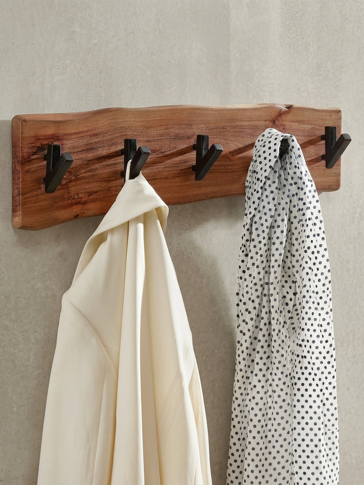 Die Hakenleiste aus Akazie in der 3/4-Ansicht, die die Tiefe der V-förmigen Haken und die natürliche Welle der Holzkante elegant zur Geltung bringt._