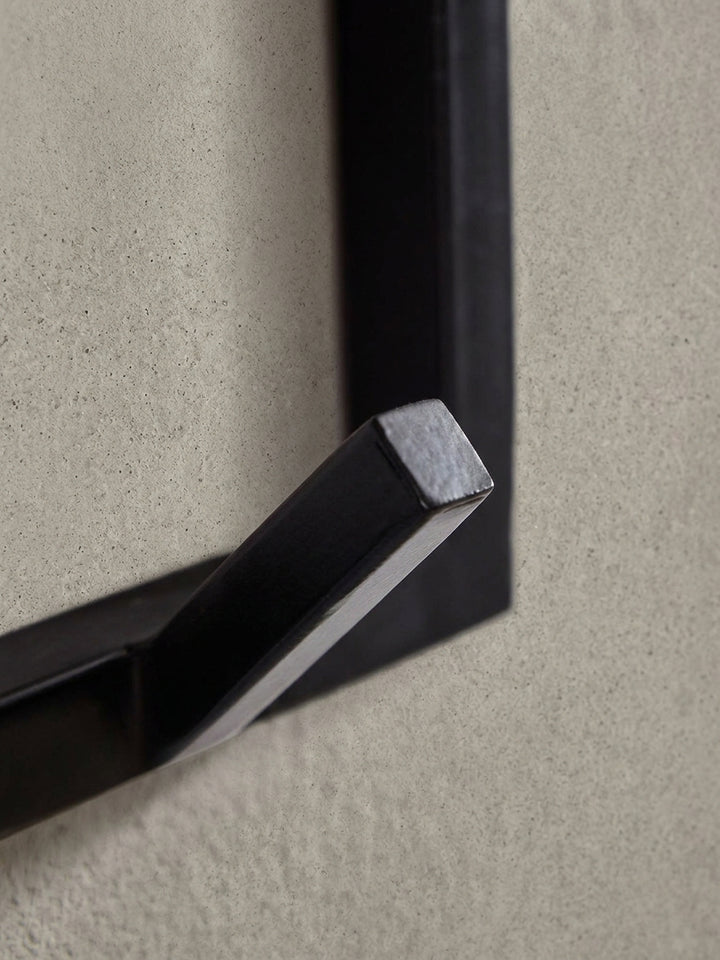 Nahaufnahme eines der stabilen Metallhaken der Flurgarderobe. Die pulverbeschichtete Oberfläche und die kantige Form sind im Detail zu sehen._