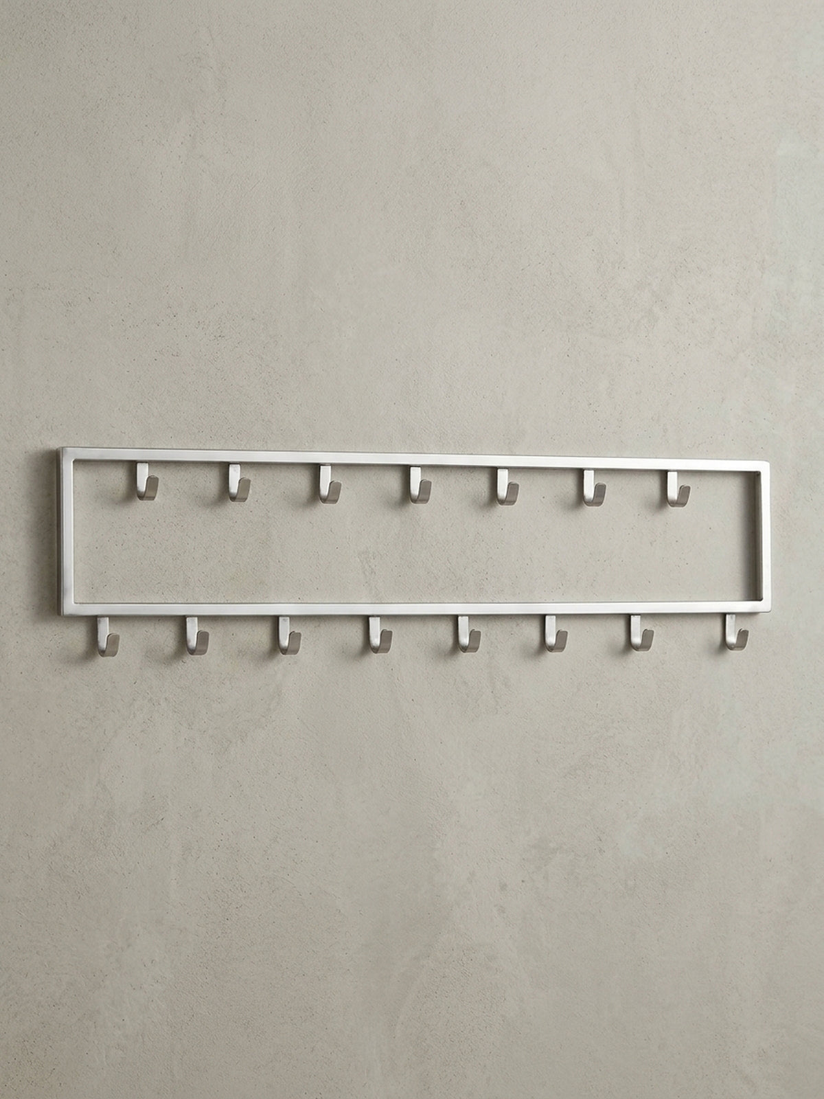 Frontalansicht der Wandgarderobe aus silbernem Stahl, 80x20 cm, mit ihrer klaren, rechteckigen Form und den 15 versetzten Haken.