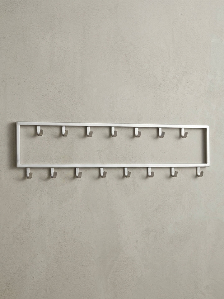Frontalansicht der Wandgarderobe aus silbernem Stahl, 80x20 cm, mit ihrer klaren, rechteckigen Form und den 15 versetzten Haken._