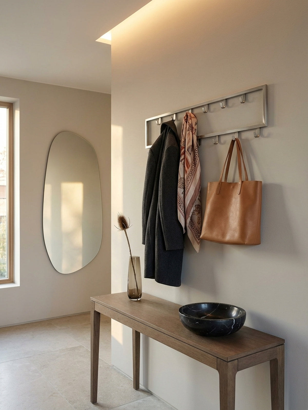 Nahaufnahme der matt polierten Stahl-Oberfläche der Design-Wandgarderobe, die die feine Bürstung und hochwertige Verarbeitung des Metalls zeigt._