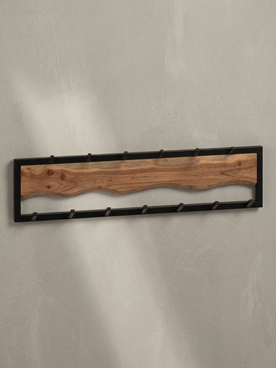 Frontansicht der Wandgarderobe mit 13 Haken, die den Kontrast zwischen dem warmen Akazienholz und dem kühlen, schwarzen Metall zeigt._