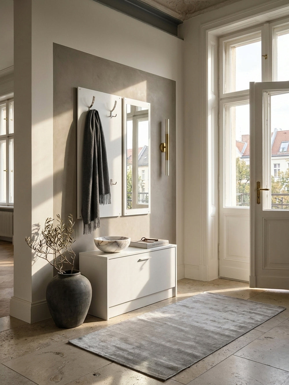 Moderne Flur-Kompaktgarderobe aus weißer Spanplatte mit Spiegel im minimalistischen Eingangsbereich auf edlem Natursteinboden_