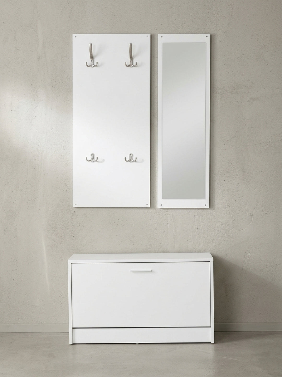 Frontalansicht der dreiteiligen Wand-Garderobe aus weißer Spanplatte mit Spiegel und schmalem Schuhkipper vor neutralem Hintergrund_