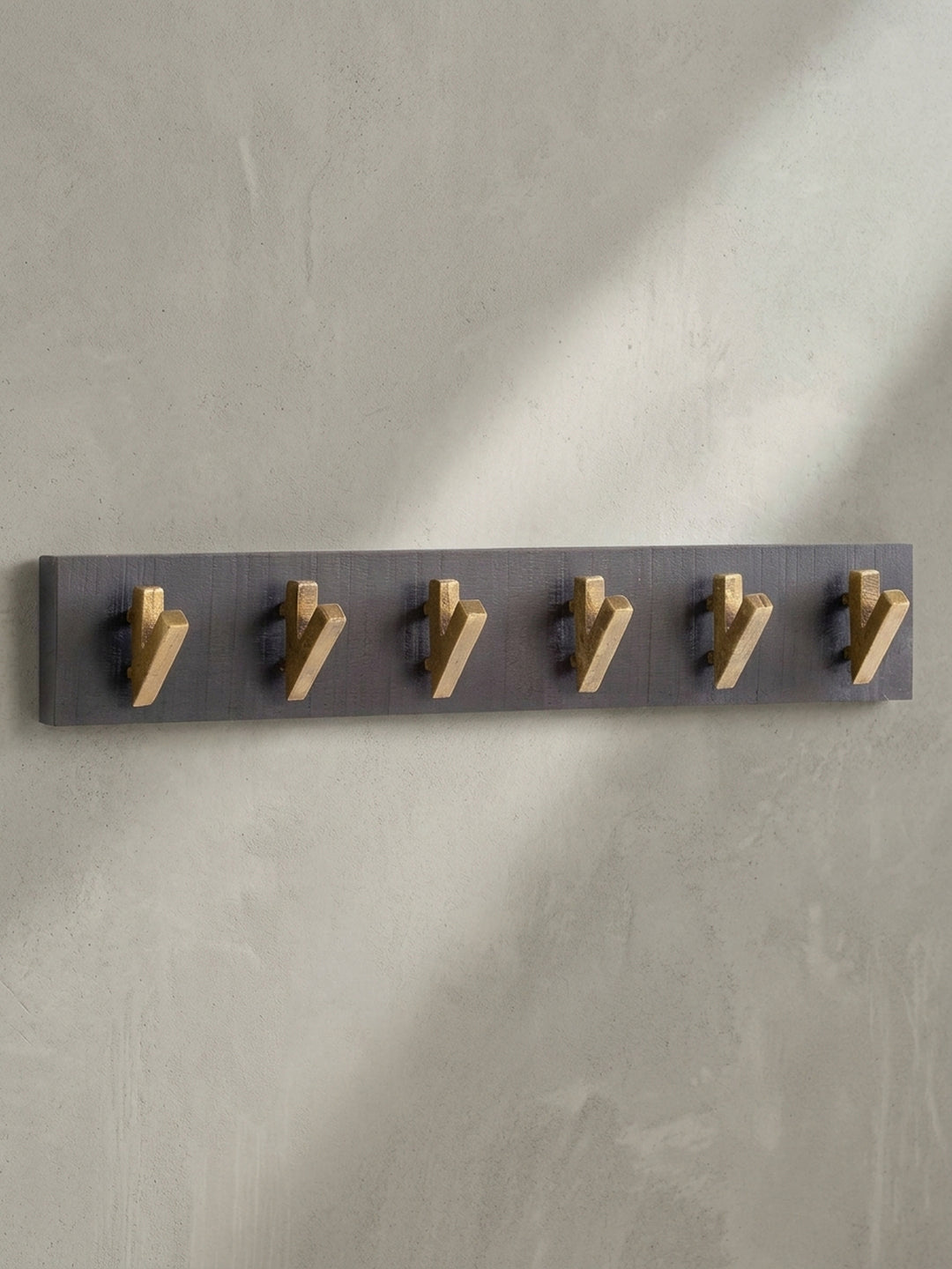 Gesamtüberblick der eleganten Hakenleiste aus schwarzem Holz und Metall, ideal für einen modernen und aufgeräumten Eingang._