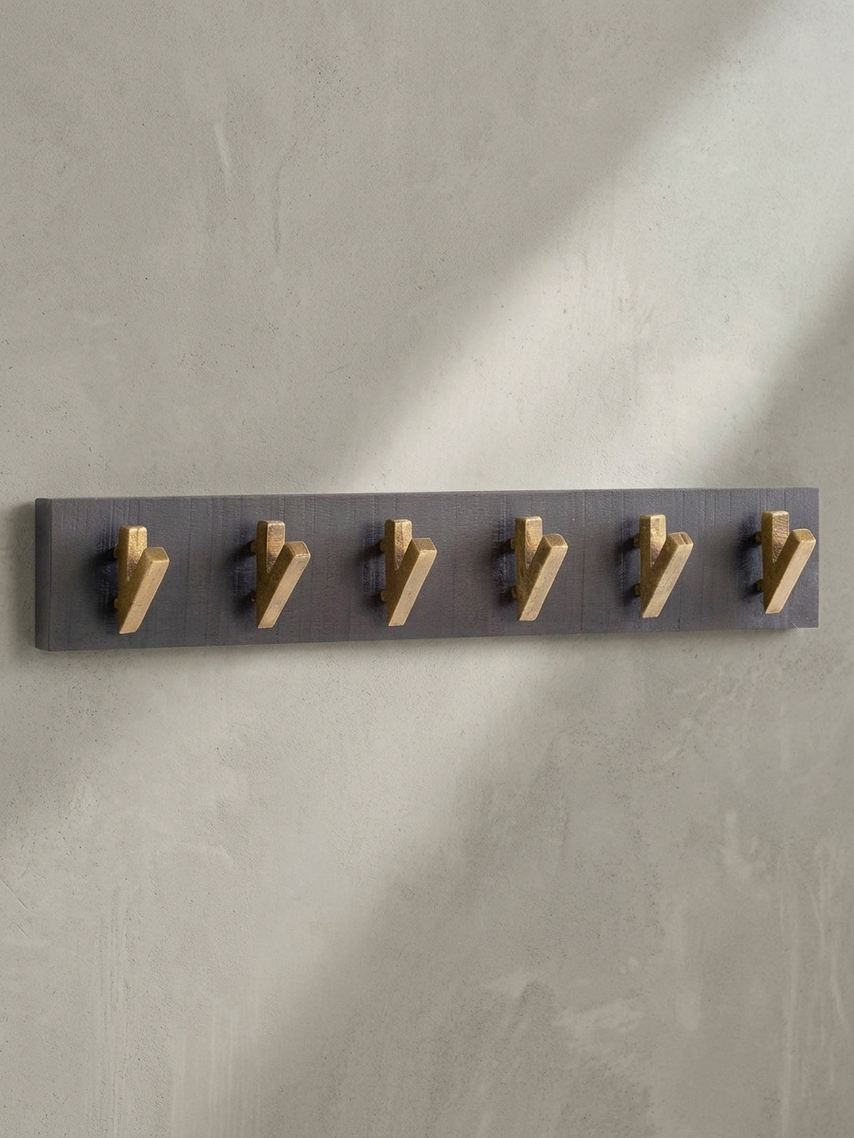 Gesamtüberblick der eleganten Hakenleiste aus schwarzem Holz und Metall, ideal für einen modernen und aufgeräumten Eingang.