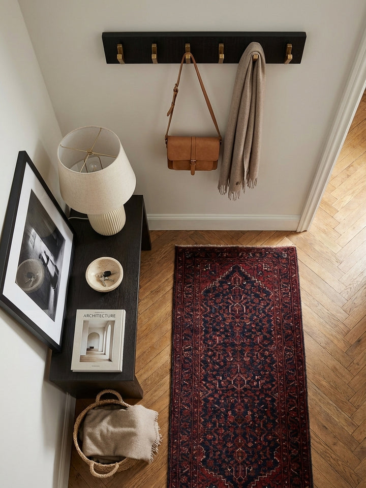 Von oben fotografierte Hakenleiste aus Massivholz, montiert in einem minimalistisch eingerichteten Eingangsbereich auf Eichenparkett._