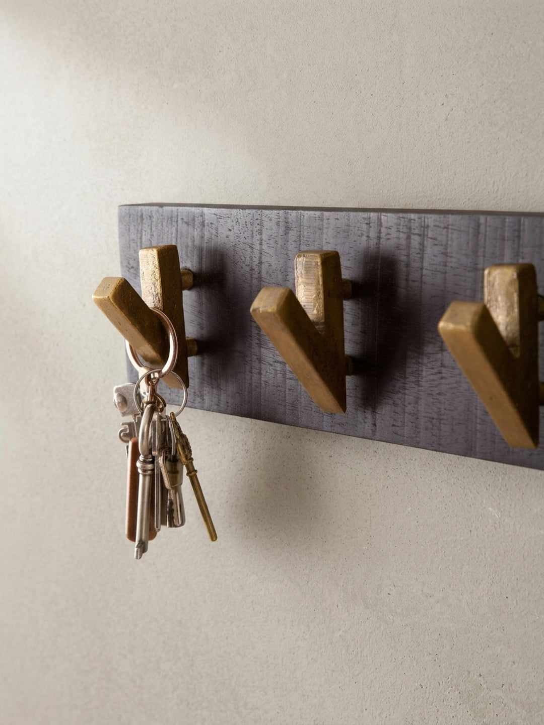 Alternative Perspektive auf die Design-Garderobe, die das Zusammenspiel von mattem Schwarz und glänzendem Gold betont._