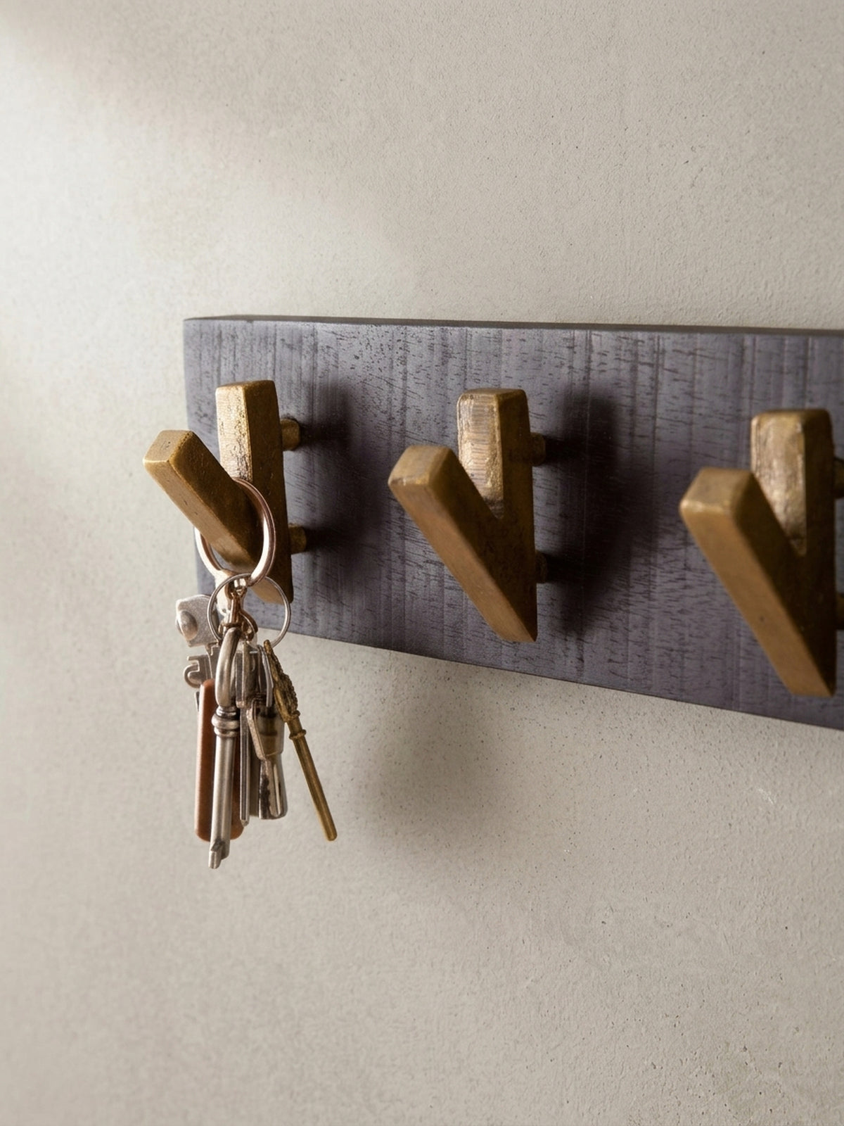 Alternative Perspektive auf die Design-Garderobe, die das Zusammenspiel von mattem Schwarz und glänzendem Gold betont.
