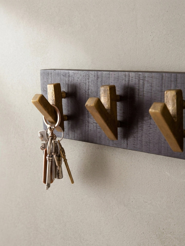 Alternative Perspektive auf die Design-Garderobe, die das Zusammenspiel von mattem Schwarz und glänzendem Gold betont._