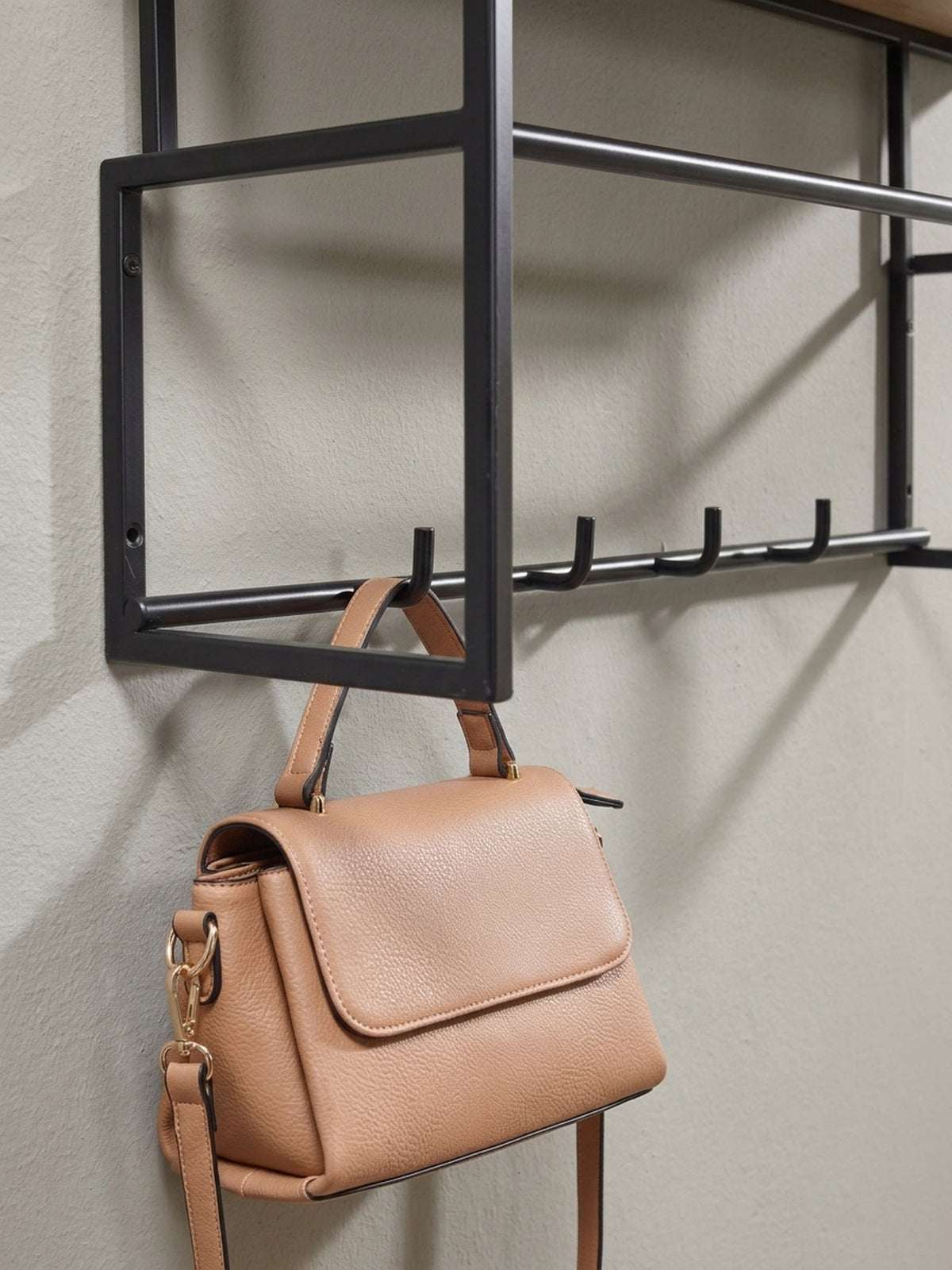 Eine weitere Perspektive der kompakten Wandgarderobe (71 cm breit), die das Zusammenspiel von der warmen Holzablage und den kühlen, schwarzen Metallhaken betont.
