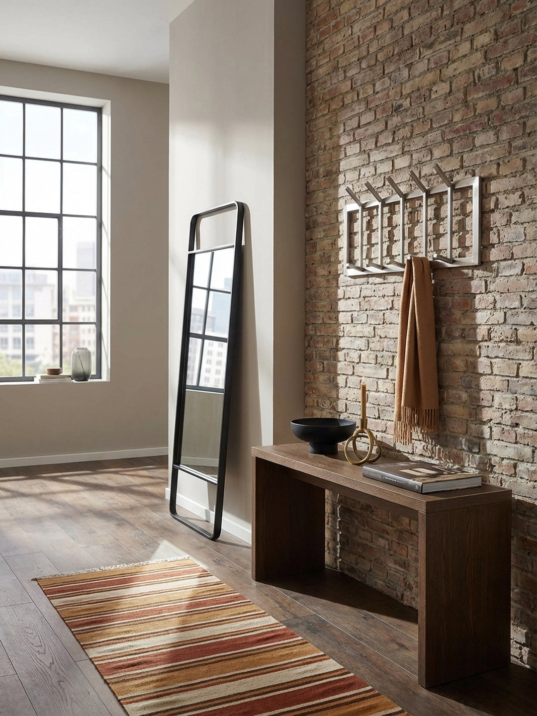 Moderne Wandgarderobe aus mattem Stahl im Flur, montiert an einer hellen Wand über einem Holzboden, elegant gestylt mit Jacke und Tasche._