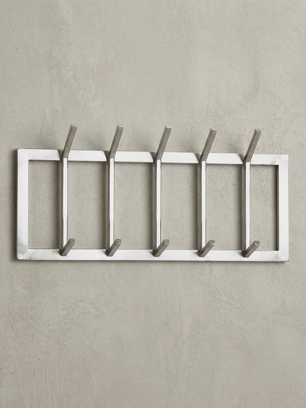 Frontalansicht der Wandgarderobe aus silbernem Stahl, 65 cm breit, mit zehn Haken auf weißem Hintergrund, die das klare, geometrische Design betont.