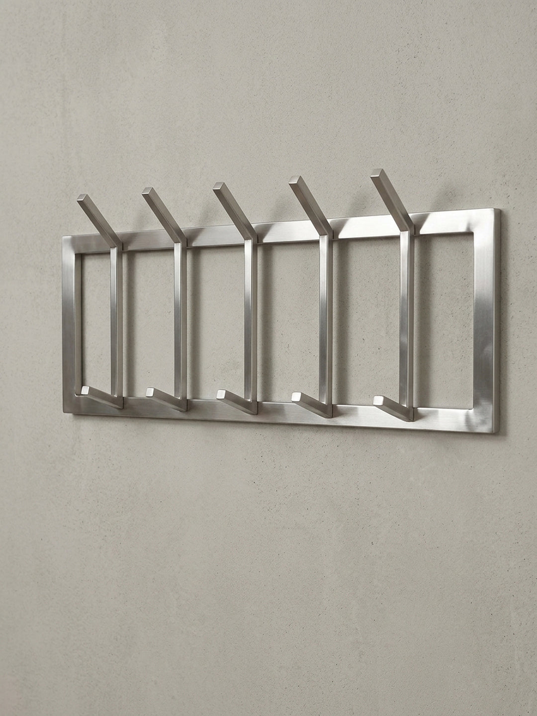 Schräge 3/4-Ansicht der Hakenleiste aus Metall, die die Tiefe von 10 cm und die stabile Konstruktion der Haken für Jacken und Mäntel zeigt._