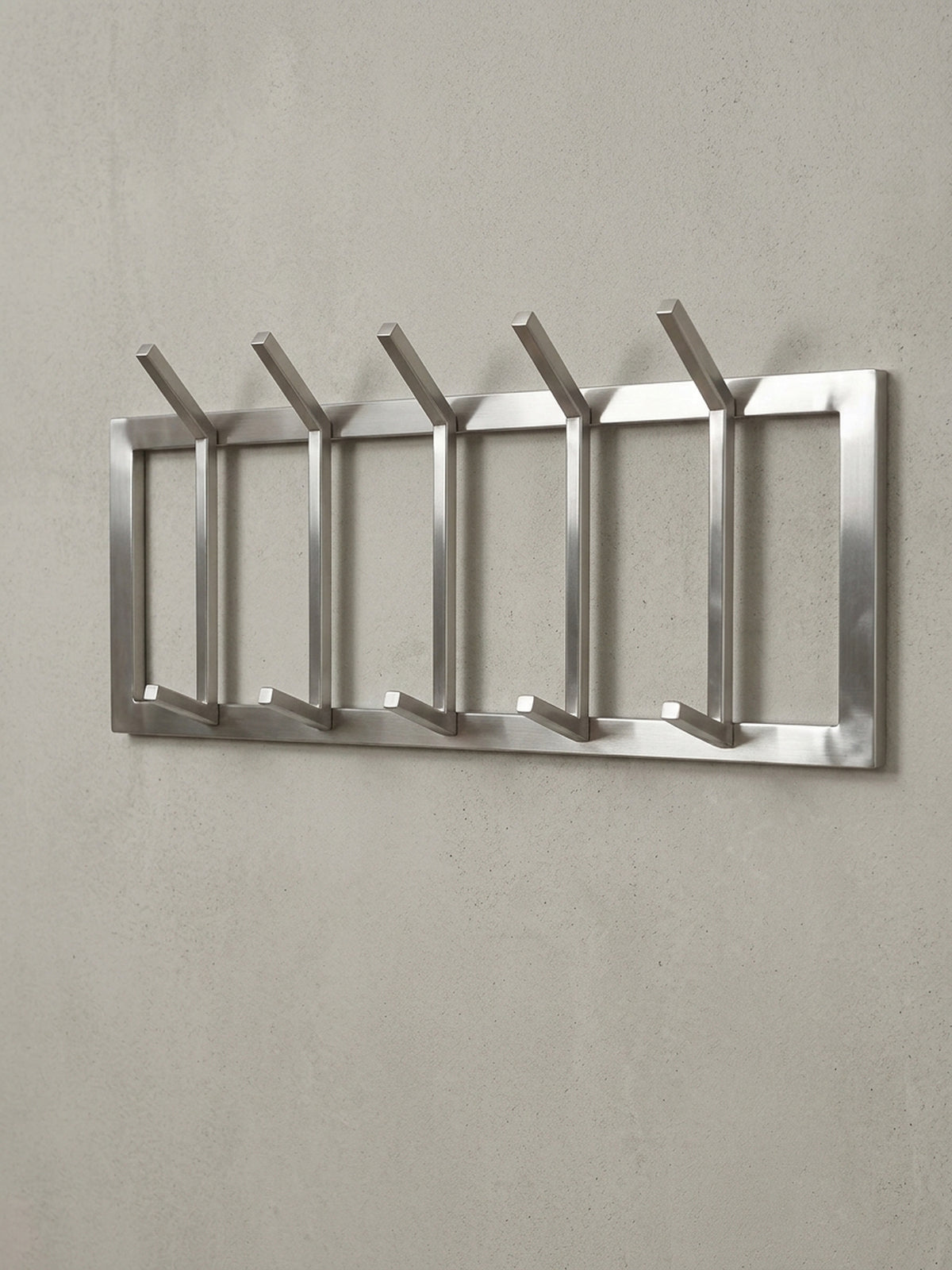 Schräge 3/4-Ansicht der Hakenleiste aus Metall, die die Tiefe von 10 cm und die stabile Konstruktion der Haken für Jacken und Mäntel zeigt.