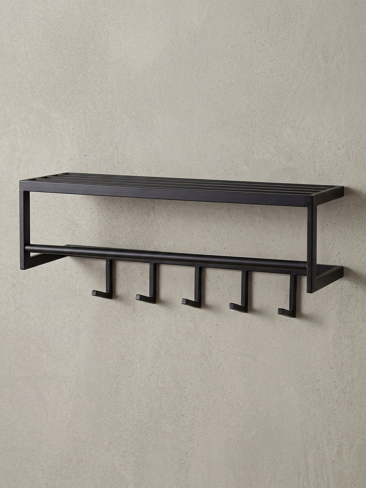 Schrägansicht der schwarzen Design-Hakenleiste aus Metall, die die räumliche Tiefe von 20 cm und die stabile Konstruktion des Wandpaneels verdeutlicht._